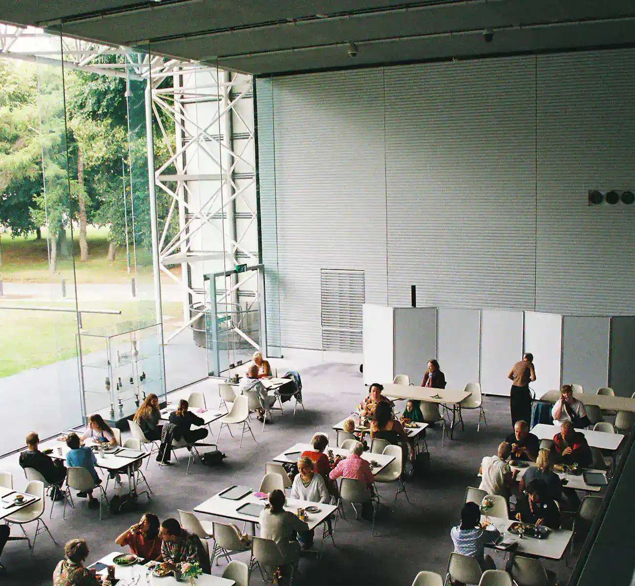 People eating at long tables in a large canteen